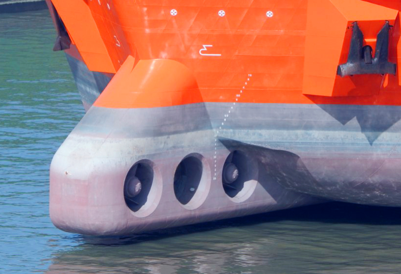 Nahaufnahme des orangefarbenen Schiffsbogens mit drei runden Öffnungen.